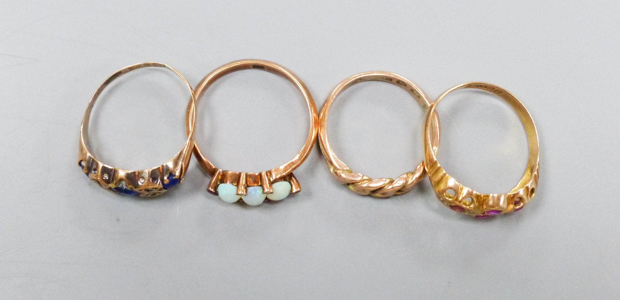 Four early 20th century 9ct gold and gem set rings including three stone opal with seed pearl spacers, gross weight 8.4 grams.